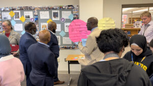 Lewis High School Principal Alfonso Smith shows members of John R. Lewis’s family the “Three Whys” heart that any visitors to the program room may write on: “Why does the Lewis Leadership Program matter to me, my community, and the world?”